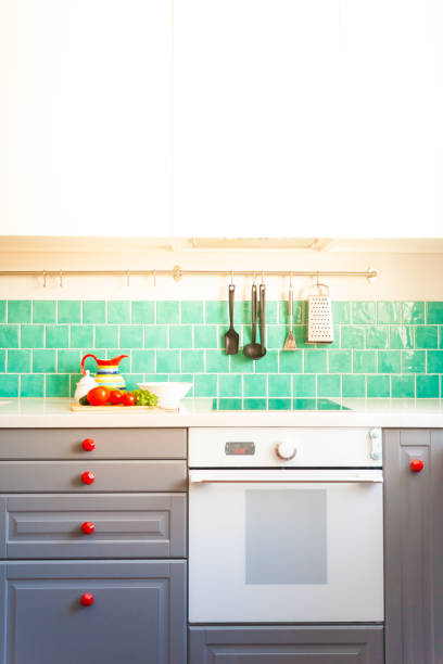 istock Kitchen features dark gray flat front cabinets paired with white quartz countertops and a glossy blue care tile. 972603150