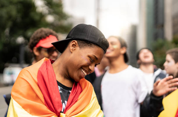 retrato de muchacho gay con amigos teniendo diversión en fondo - homosexual rainbow gay pride flag flag fotografías e imágenes de stock