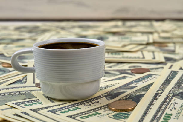 istock Coffee on dollar bills pile. 972617428