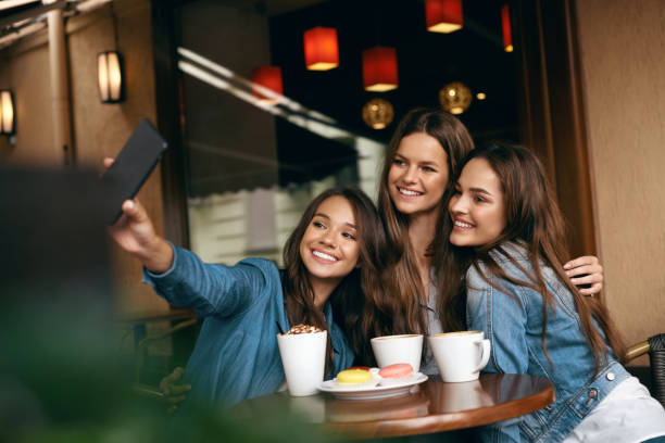 istock Beautiful Friends Taking Photos In Cafe. 972620614