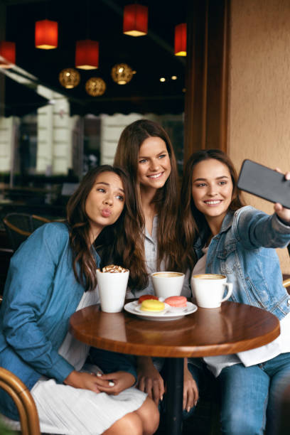istock Beautiful Friends Taking Photos In Cafe. 972620710