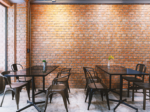 Modern cafe in loft style, black table set for coffee with brick wall