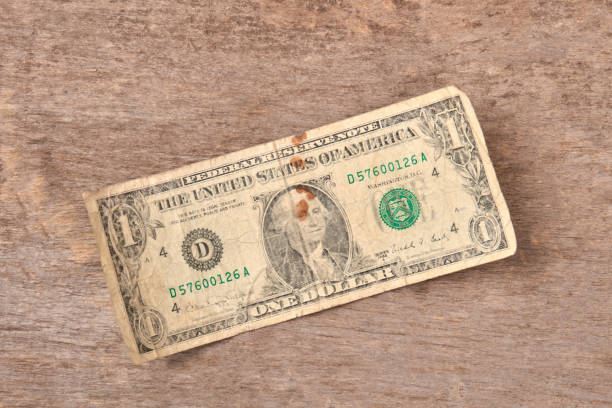 istock One dollar bills on a wooden background. 972626364