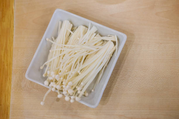 istock Golden needle mushroom in white ceramic tray 972627436