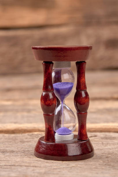 istock Hourglass with purple sand. 972627472