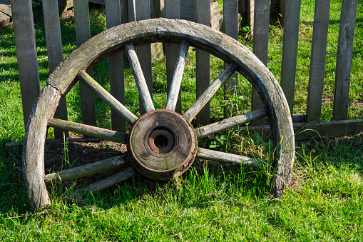 broken vintage wooden wheel as decoration in garden
