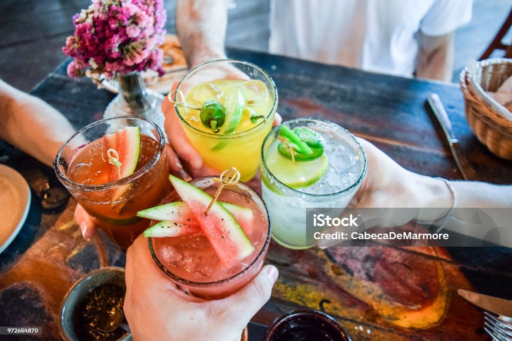 Friends toasting, saying cheers holding tropical blended fruit margaritas.  Watermelon and passionfruit drinks.; Shutterstock ID 780298633 - 로열티 프리 칵테일 스톡 사진