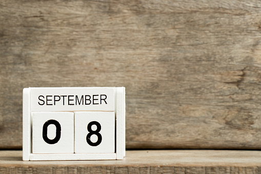 White block calendar present date 8 and month September on wood background
