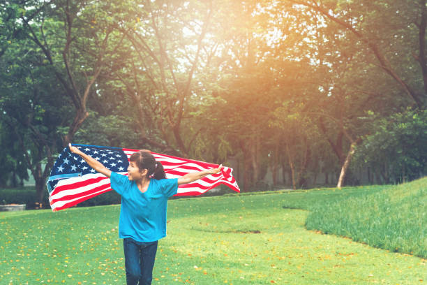 happy kid little child running with american flag usa celebrate 4th of july - child flag fourth of july little girls imagens e fotografias de stock