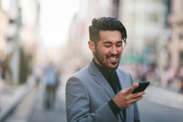 istock Happy young Japanese businessman using smartphone 972664752
