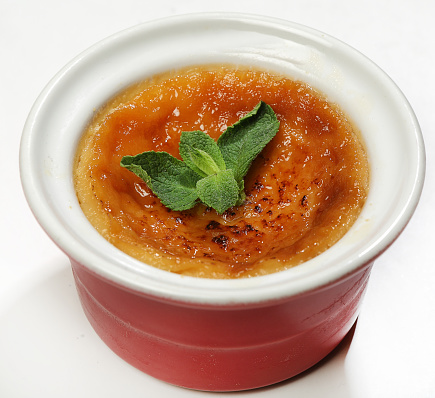 Creme brule-a delicate creamy dessert decorated with mint leaves, close-up