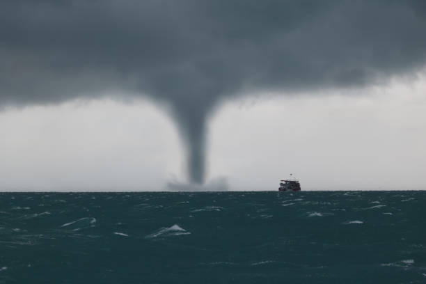 istock Tornado and storm cloud in the sea while the ship is sailing. 972674704