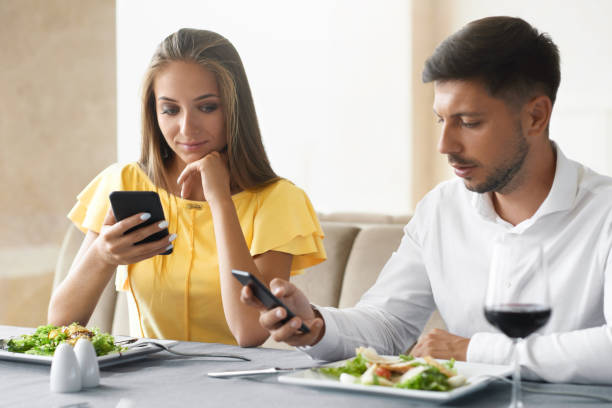 istock Couple Using Phones On Dinner In Restaurant. 972680688