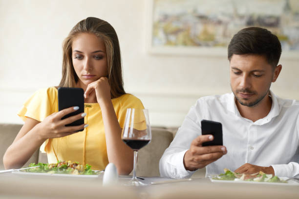 istock Couple Using Phones On Dinner In Restaurant. 972680734