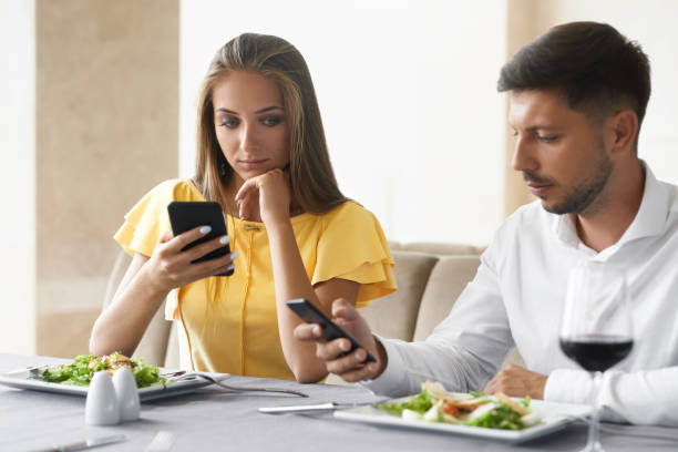 istock Couple Using Phones On Dinner In Restaurant. 972680782