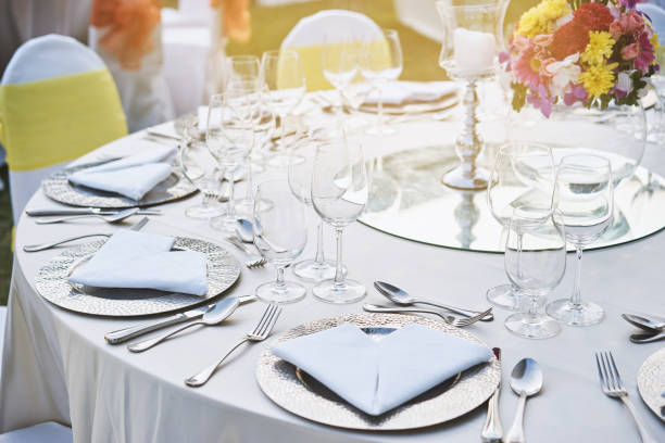 istock Closeup of wedding reception dinner table setting with water glasses, napkin, plate, spoon and fork 972683844