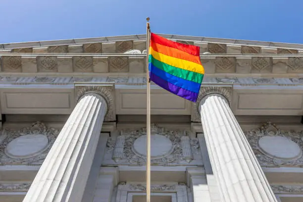 High Quality stock photo of rainbow flag flying out side San Francisco City Hall.