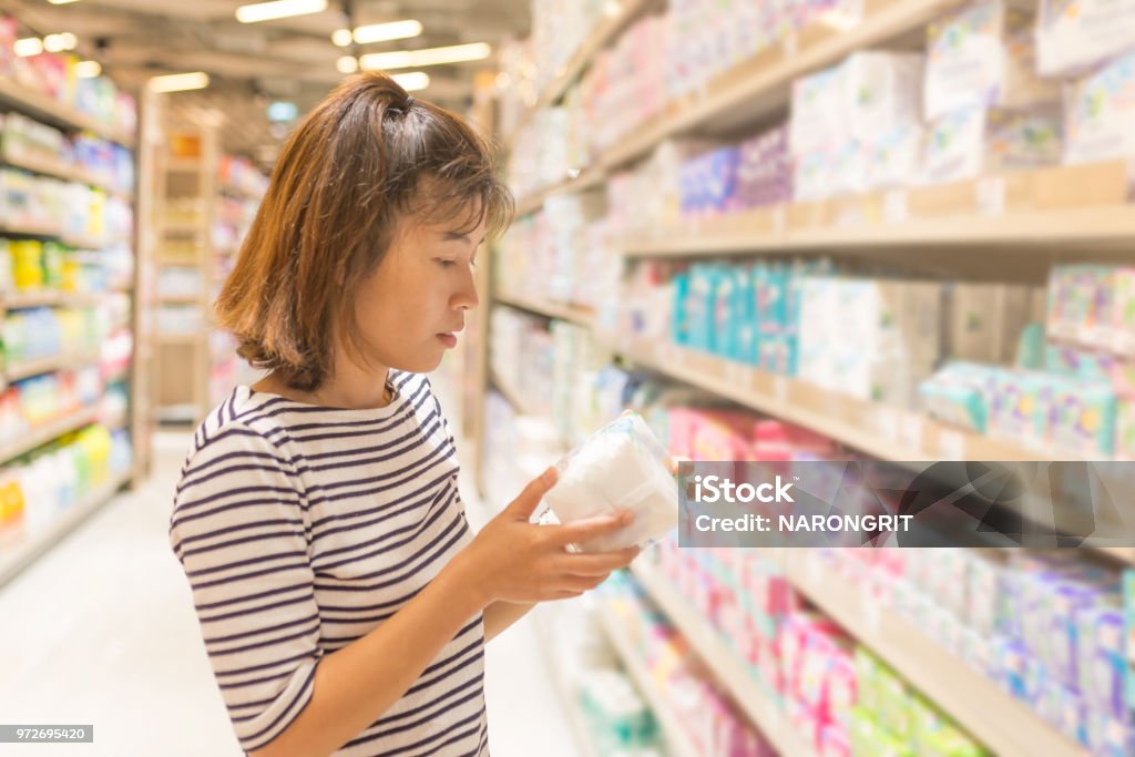 Asian Woman shopping sanitary napkin at the supermarket. Sanitary Pad Stock Photo