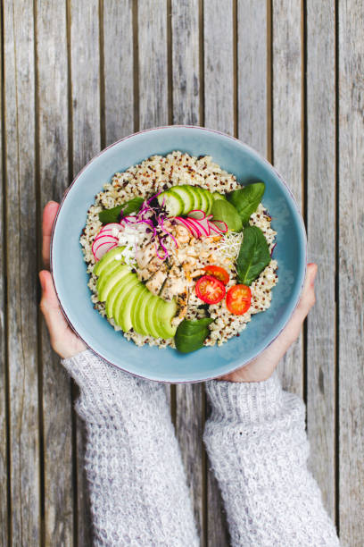 istock Cropped Hands Holding Salad Bowl On Table 972705026