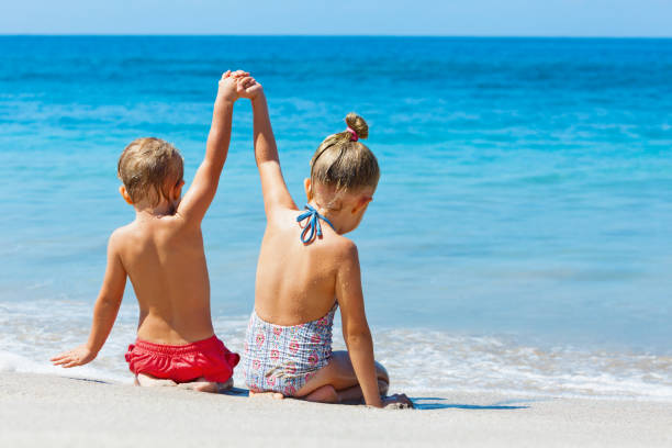 i bambini felici si divertono nel campo estivo durante le vacanze al mare - couple human hand holding walking foto e immagini stock