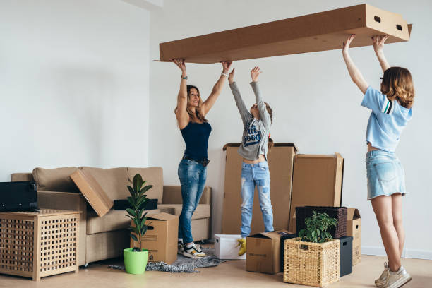 istock Mother two children at new home with cardboard boxes. 972709964