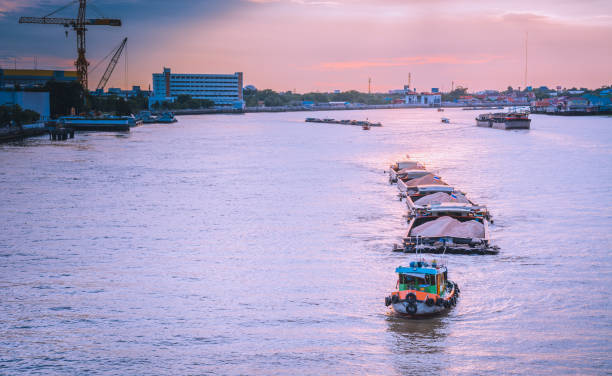 istock The tug boats towing a big barge with sand. 972713092