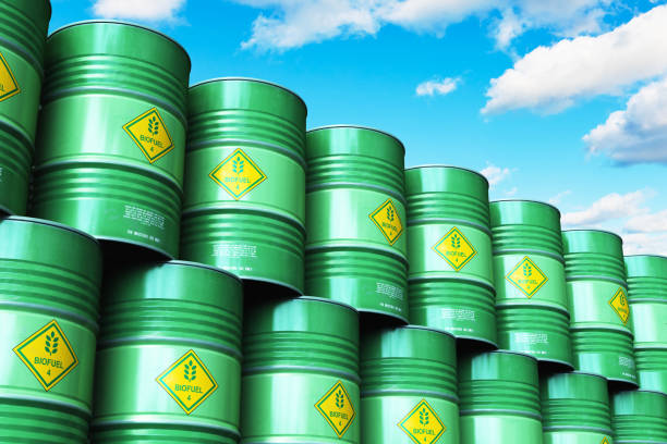 istock Group of green stacked biofuel drums against blue sky with clouds 972721856