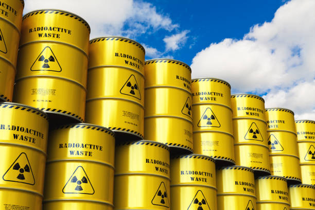 istock Group of stacked yellow drums with radioactive waste against blue sky 972721866