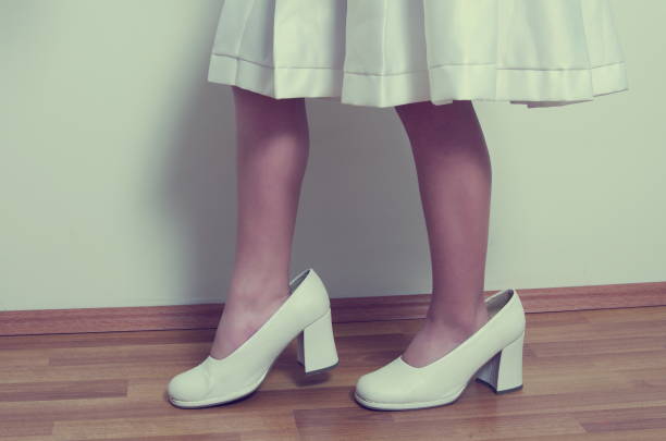 istock Low Section Of Woman Wearing Oversized High Heels On Hardwood Floor 972722086
