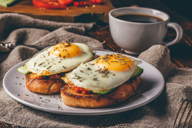 istock Italian toasts with vegetables and fried eggs on white plate and 972722322