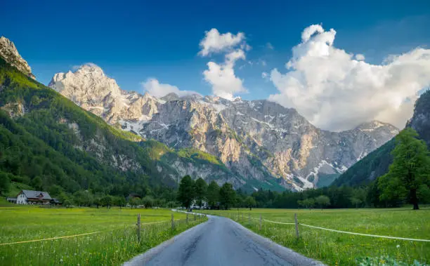 Shot at the entry of Logarska valley in the eventing, as sun graces the southern side of the Kamnik-Savinja Alps. The main peaks being from left to right; Ojstrica, Planjava and Kamniško Sedlo, over which the clouds are blowing. In the foreground meadow we can still see the last of the dandelions as they bloom away.