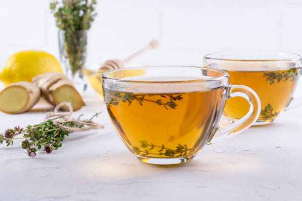 winter drink. warming hot tea with lemon, ginger, and herbs thyme, copy space - ginger tea cup cold and flu tea imagens e fotografias de stock