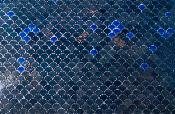 Tiles wall. The dark blue navy tiles wall with under the sea inspiration of fish scale and mermaid pattern. Window light. stock photo
