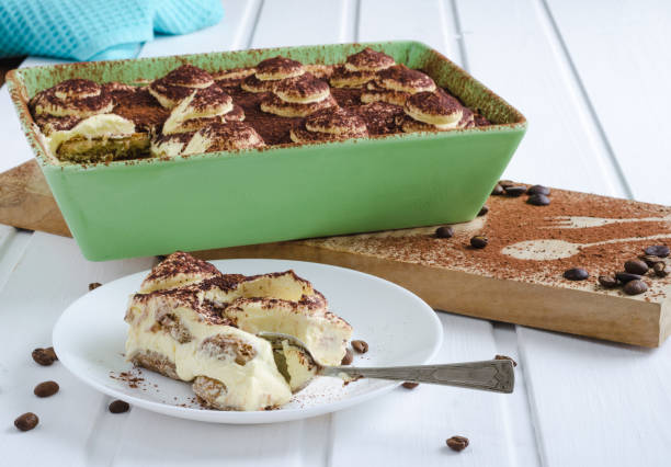 istock Portion of tiramisu in white plate on wooden background. Flat lay. 972734752