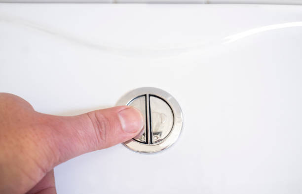 istock Finger pushing a flush toilet button for cleaning. Full discharge button 972739008