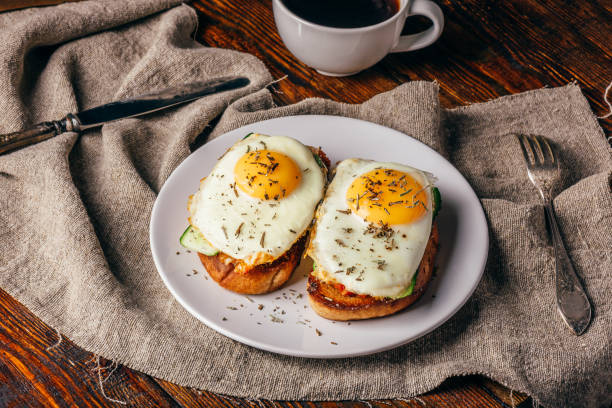 istock Italian toasts with vegetables and fried eggs on white plate and 972739298
