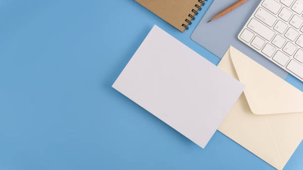 istock Flat lay, top view office table desk. Workspace with blank note book, keyboard, office supplies and coffee cup on light blue background. 972746270