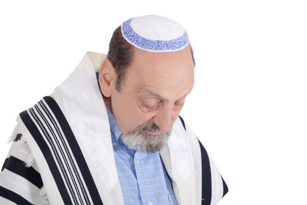 Eldery jewish man with kippah and wrapped in talit praying. Religion concept. Isolated white background