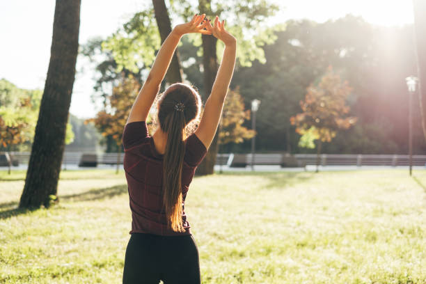 istock Sporty girl doing warm-up in the morning park 972755924