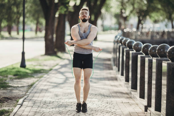 istock Fit muscular man jumping using skipping rope outdoors 972769820