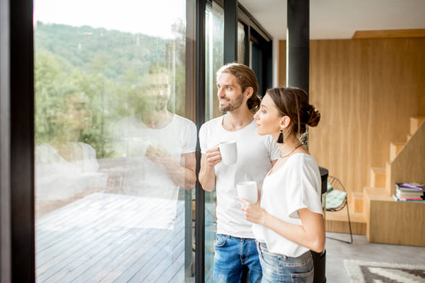istock Couple standing near the window indoors 972775454