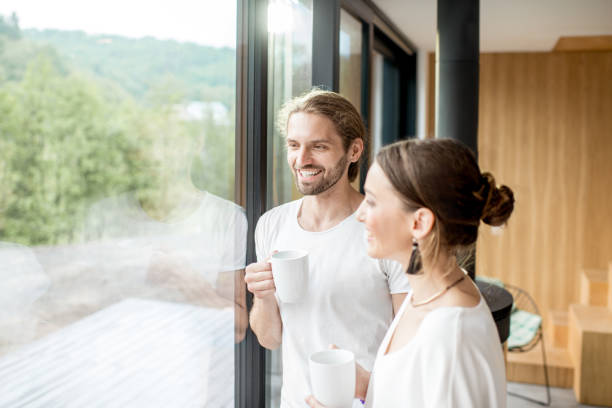 istock Couple standing near the window indoors 972775532