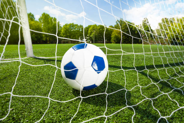 istock Football soccer ball though the gates net 972788218