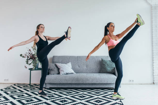 istock Fit woman stretching legs warming up workout at home 972791604