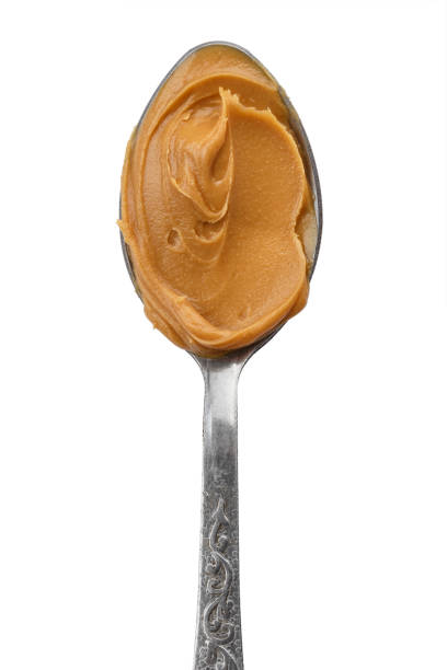 istock spoon with natural organic peanut butter, on white background 972794406