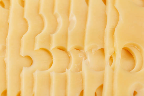 istock sliced cheese with big holes as background 972795386