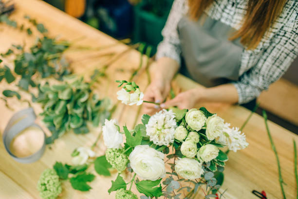 istock Female florist with pruner in hands makes bouquet 972848858
