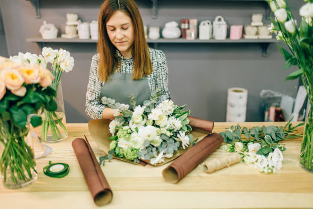 istock Female florist decorate fresh flower composition 972849232