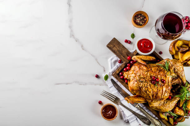 Baked chicken with cranberry and herbs Christmas, thanksgiving food, baked roasted chicken with cranberry and herbs, served with fried vegetables, fresh berries wine and sauces on white marble table, copy space top view sauces table turkey christmas stock pictures, royalty-free photos & images