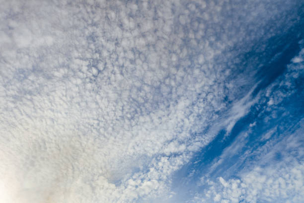 istock Beautiful cirrus clouds on a dark blue sky in sunny light. Heavenly background. Universal template for background insertion. 972852308